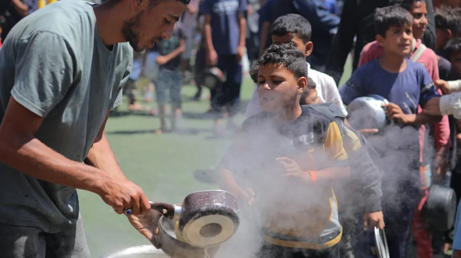 Palestinian children receive meals from volunteers in Gaza City, on May 29, 2025. Photo by Ali Hassan/Flash90.