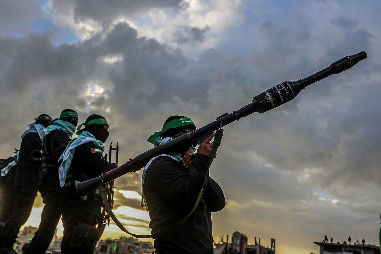 Members of the Al-Qassam Brigades and Palestinians waiting for the hand over of the bodies of four late Israeli hostages to the Red Cross, as part of the ceasefire agreement between Israel and Hamas, in Khan Yunis, Feb. 20, 2025. Photo by Abed Rahim Khatib/Flash90.