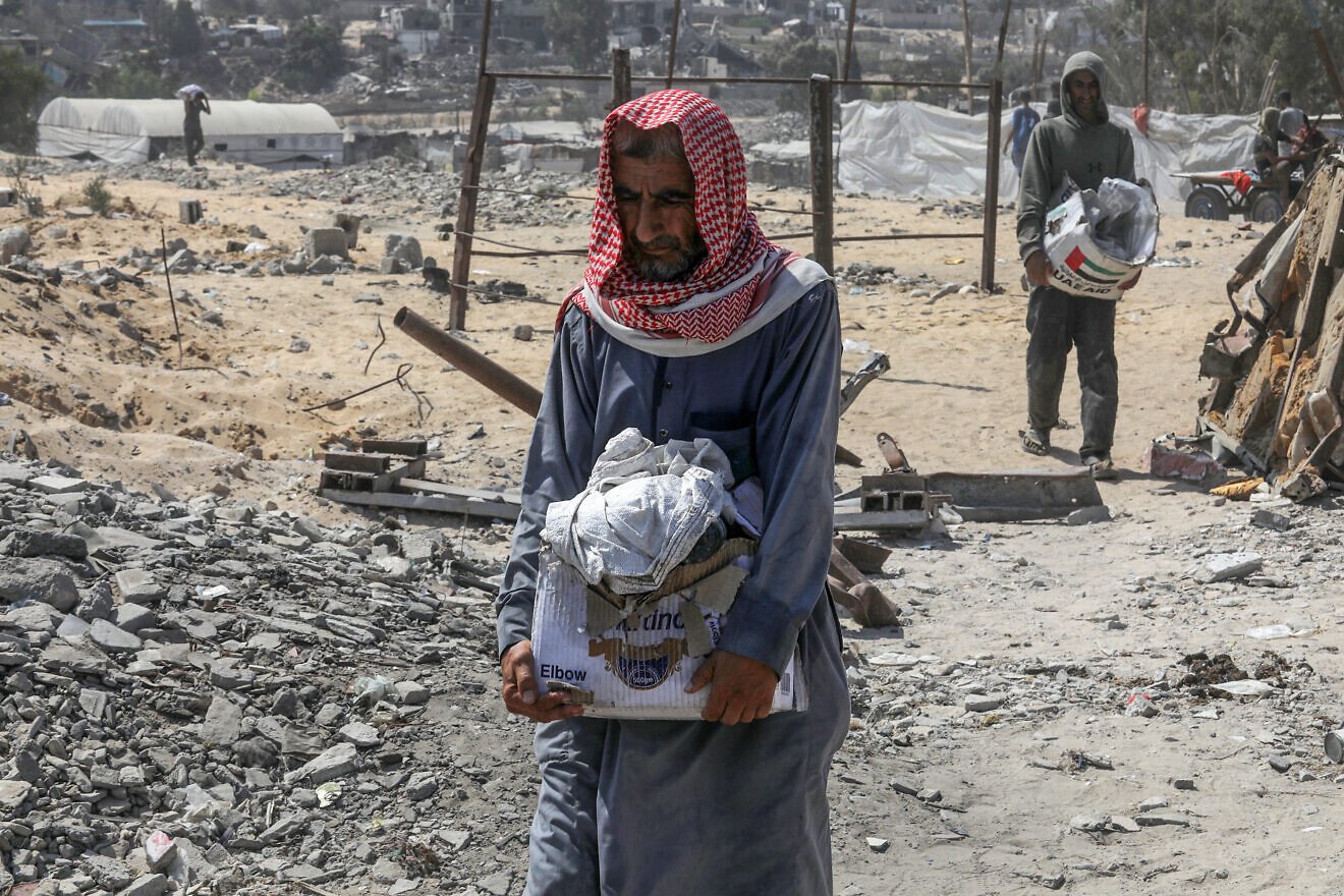 An older Palestinian man carries humanitarian aid in Rafah, in the southern Gaza Strip, Aug. 14, 2025. Photo by Abed Rahim Khatib/Flash90.