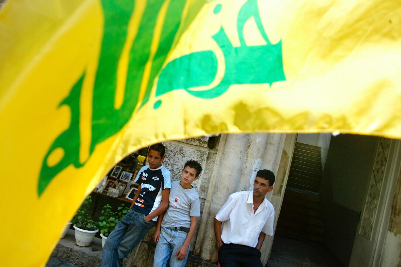 Palestinians stand nearby a Hezbollah flag in Ramallah on Aug. 9, 2006. Credit: Olivier Fitoussi/Flash90.
