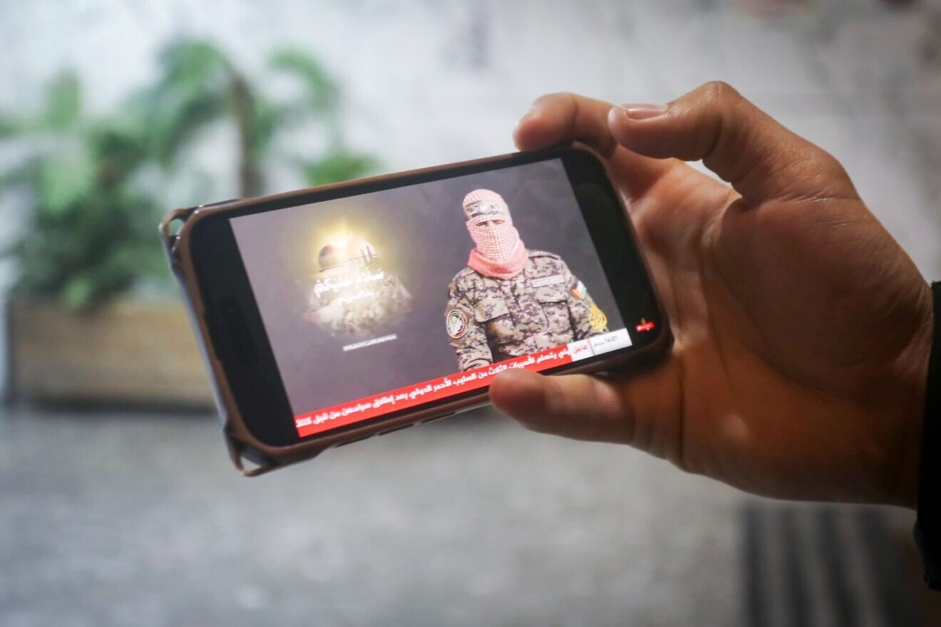 A Palestinian man watch a speech by the spokesman of the Qassam Brigades, known as Abu Obeida, in the West Bank city of Nablus. on Jan. 19, 2025. Photo by Nasser Ishtayeh/Flash90,