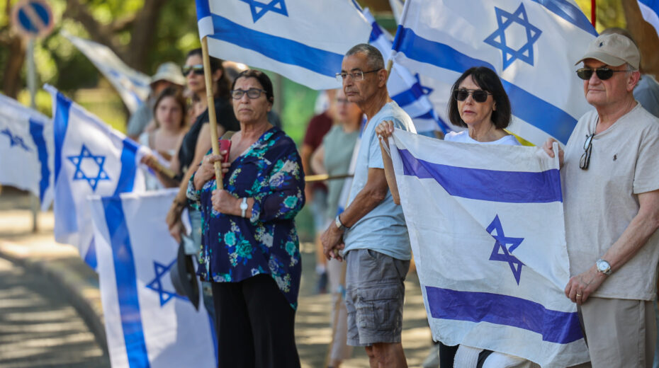 A sad tradition: People in Modi'in hold Israeli flags to pay their respects to fallen soldier Ofir Berkovich. She was killed in fighting in the Gaza Strip on October 20, 2024. Photo: Jonathan Shaul/Flash90