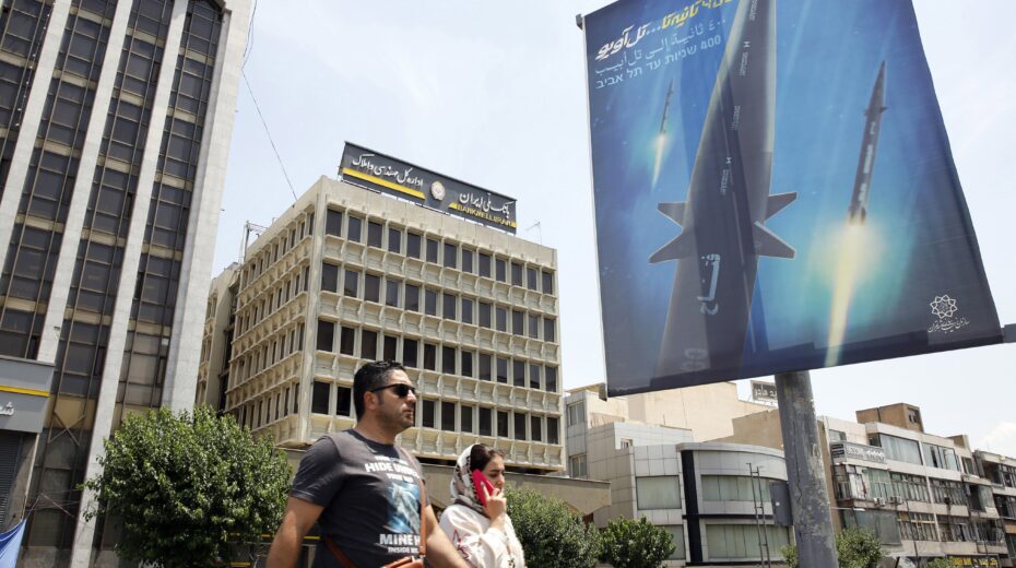 Iranians walk past a billboard in Tehran on June 8, 2023, displaying a photo of the new Fattah hypersonic missile and the words "400 seconds to Tel Aviv" in Persian and Hebrew. Photo: EPA/ABEDIN TAHERKENAREH