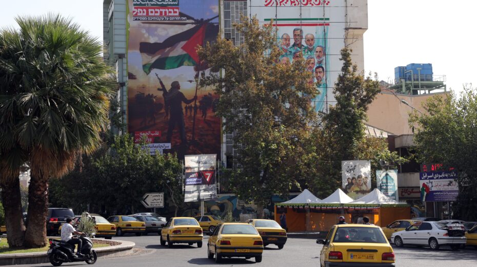 Iranians drive past a pro-Palestinian poster that reads in Persian: “In the end, you returned as losers.” Photo taken on October 15, 2025, at Palestine Square in Tehran. Photo: EPA / Abedin Taherkenareh