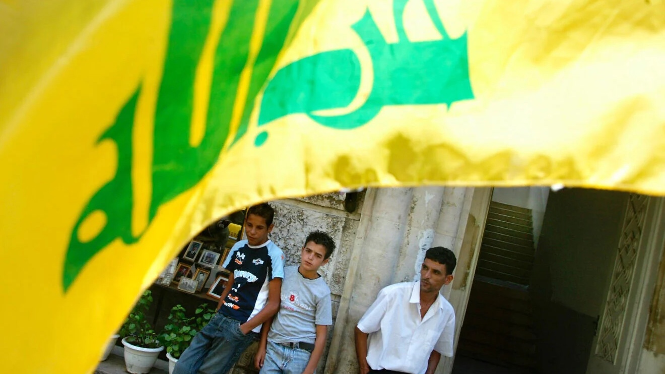 Palestinians stand near a Hezbollah flag in Ramallah, Samaria, on Aug. 9, 2006. Photo by Olivier Fitoussi/Flash90.