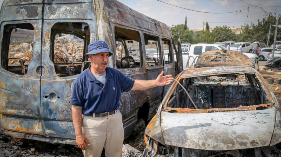 Ali Ahmed al-Tous points to the burned remains of his vehicle after a settler attack on his village of Al-Jaba near Bethlehem on October 19, 2025. Photo: Wisam Hashlamoun/Flash90