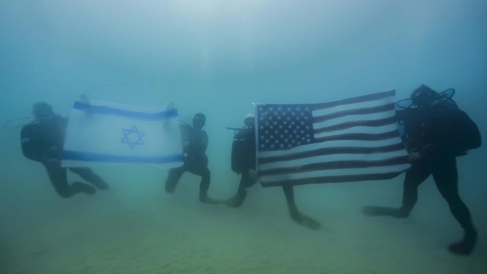 Israeli and American naval commandoes display their flags while conducting an underwater exercise. Photo: IDF Spokesman