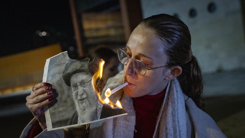 Israelis symbolically light cigarettes on burning photos of the slain Iranian "supreme leader." Photo by Chaim Goldberg/Flash90