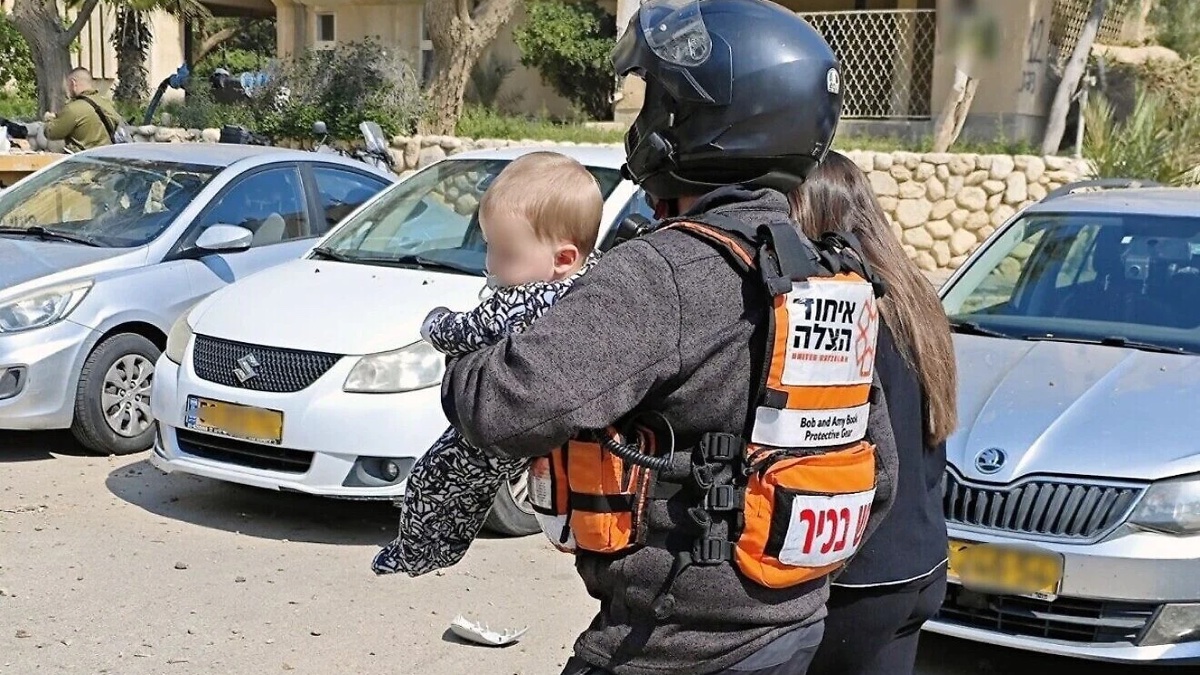 A United Hatzalah volunteer carries a baby from the scene of an Iranian missile strike in Beersheba, March 2, 2026. Credit: United Hatzalah.
