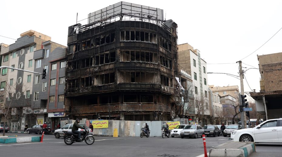 Iranians drive past a burned-out Bank Melli branch in Tehran on January 19, 2026. The destruction occurred during nationwide protests - could the war further exacerbate these internal pressures and trigger upheaval? Photo: EPA/Abedin Taherkenareh