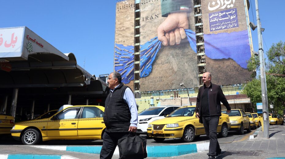 Iranians walk past a billboard relating to the Strait of Hormuz in Vanak Square in Tehran, April 15, 2026. Photo: EPA/ABEDIN TAHERKENAREH