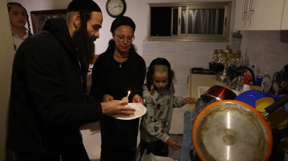 An ultra-Orthodox Jewish family during the traditional search for chametz (bedikat chametz) on the eve of Passover in Safed, northern Israel, March 31, 2026. Photo: David Cohen/Flash90