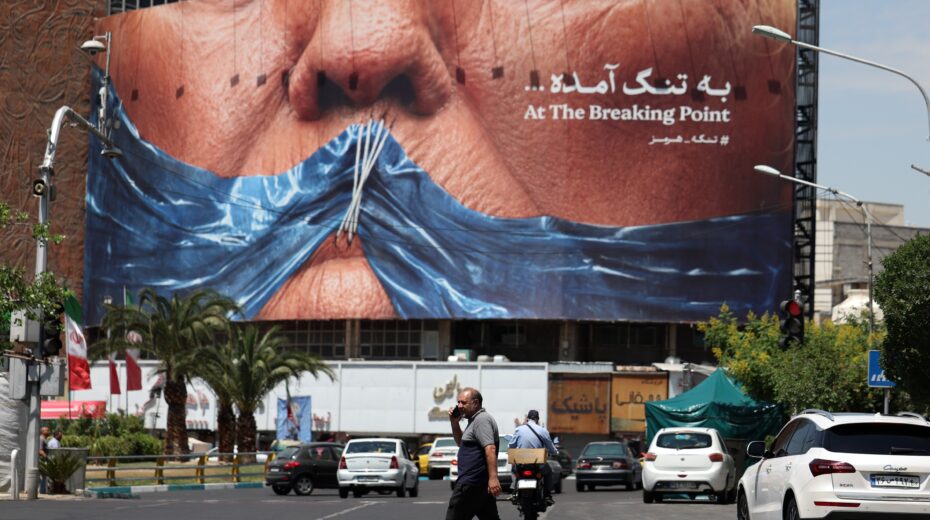 Iranians walk past a large anti-American poster depicting US President Donald Trump and the Strait of Hormuz – photographed at Valiasr Square in Tehran on May 21, 2026. Photo: Abedin Taherkenareh/EPA