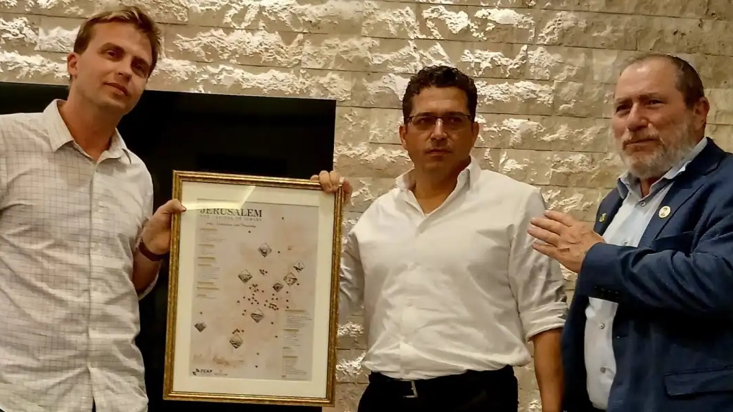 Jerusalem Deputy Mayor Adir Schwartz presents Israeli Minister of Diaspora Affairs and Combating Antisemitism Amichai Chikli with an award recognizing his work defending Jerusalem as Israel’s capital as JCAP founder and chairman Chaim Silberstein looks at the organization’s Jerusalem headquarters, July 20, 2026. Photo by Atara Beck.