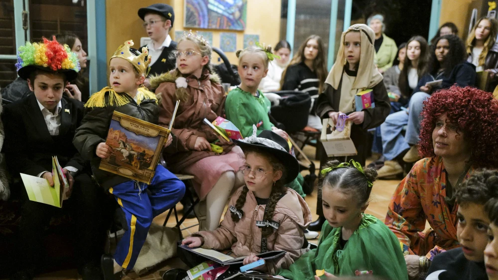 Children listen to the story of Esther (Megillat Esther) on the eve of the Jewish holiday of Purim, at a house in Kibbutz Hukok, in northern Israel, March 2, 2026. Photo by Michael Giladi/Flash90.