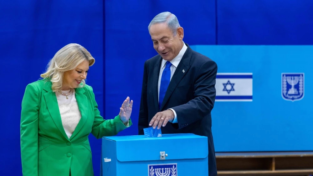Likud Chairman Benjamin Netanyahu casts his ballot at a voting station in Jerusalem alongside his wife, Sara, on Nov. 1, 2022. Photo by Olivier FitoussiFlash90.
