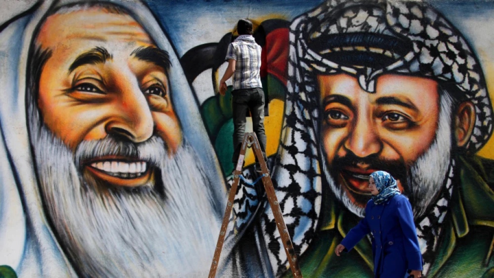 Palestinian artist Mohammed al-Dairi paints a mural of late Palestinian Liberation Organization leader Yasser Arafat (right) and late Hamas leader Sheikh Ahmed Yassin in Gaza City on March 13, 2012. Photo by Wissam Nassar/Flash90.