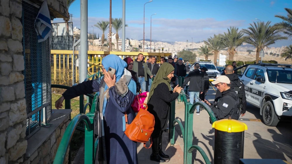 Palestinian workers line up at the entrance to the Israeli city of Ma’ale Adumim in Judea following an attempted stabbing attack, Feb. 23, 2023. Photo by Jamal Awad/Flash90.