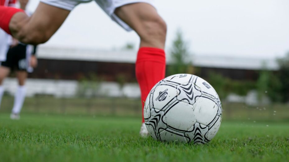 People playing soccer on a field. Credit: BOOM Photography/Pexels.
