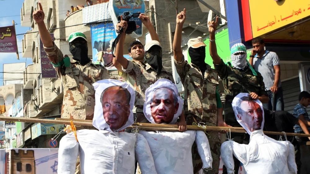 From left: Effigies of the late Israeli prime minister and president Shimon Peres, Israeli Prime Minister Benjamin Netanyahu and former Israeli defense minister and prime minister Ehud Barak carried by members of Hamas’s Al-Qassam Brigades, as they march during a rally marking the 13th anniversary of the so-called Al-Aqsa uprising or “Second Intifada” in Nusairat, in the central Gaza Strip, on Sept. 27, 2013. Photo by Abed Rahim Khatib/Flash90.
