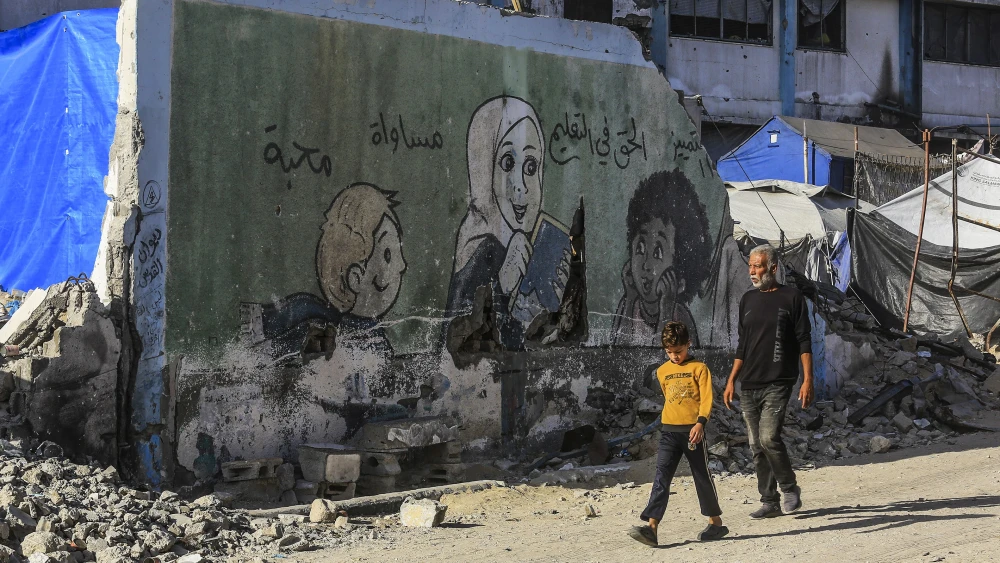 A Palestinian man and boy walk among the rubble of destroyed buildings in Khan Yunis, in the southern Gaza Strip, on Oct. 21, 2025. Photo by Abed Rahim Khatib/Flash90.