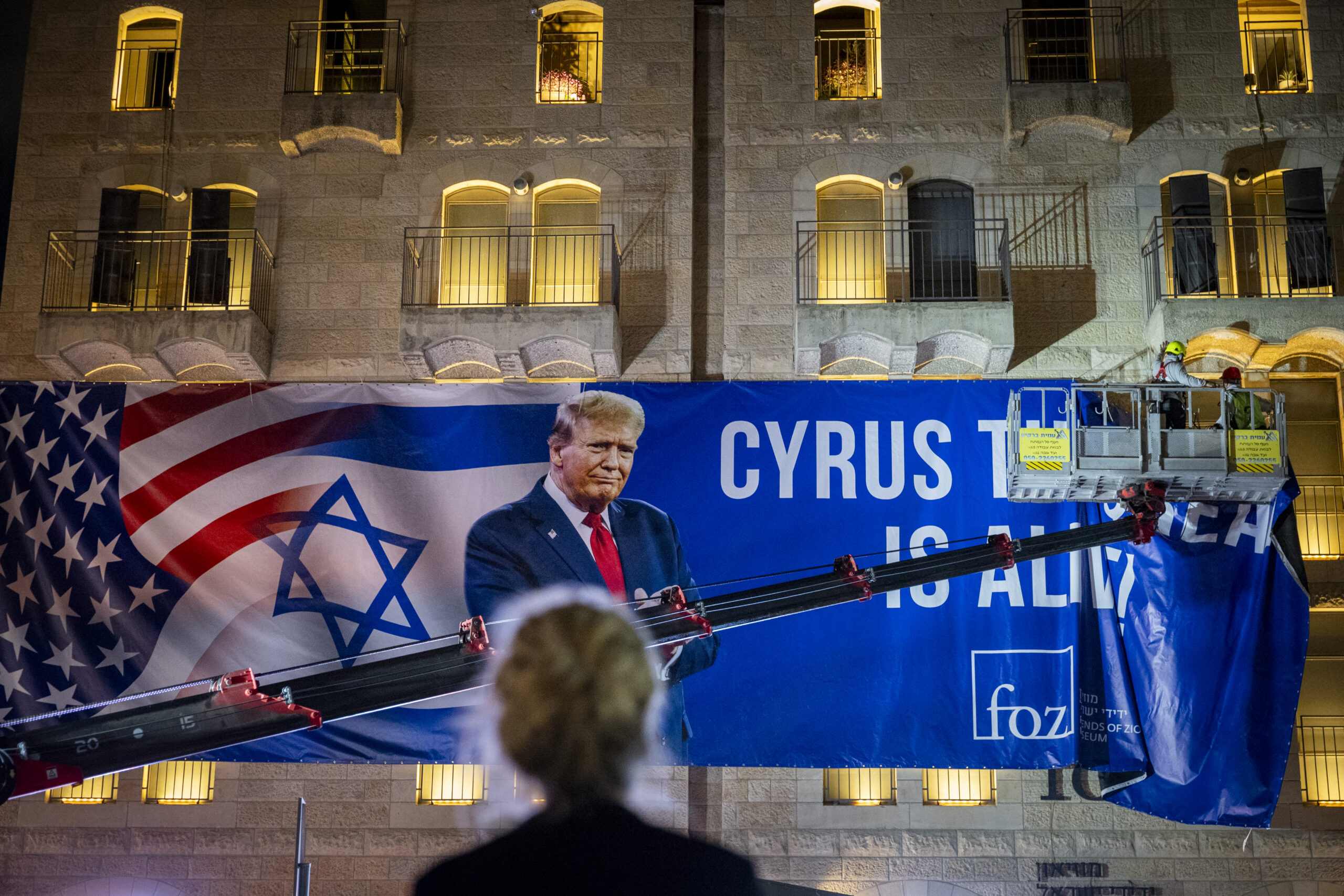 Workers hang a large banner featuring an image of US President Donald Trump in Jerusalem on October 12, 2025. Photo: Yonatan Sindel/Flash90