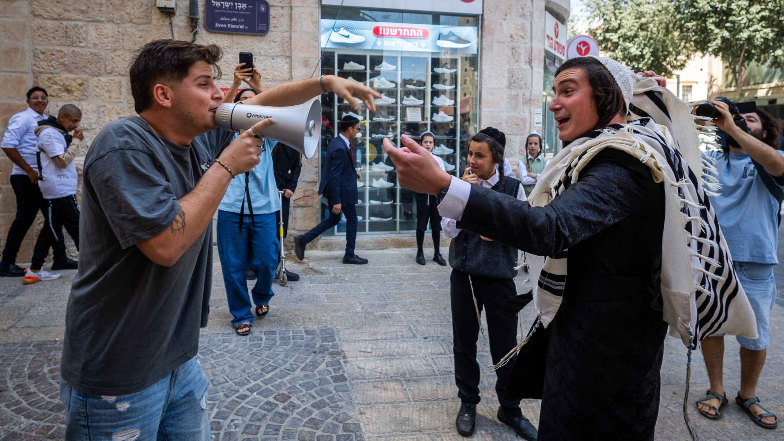 Religious and secular Israelis face off during a demonstration over the opening of a café on Shabbat in Jerusalem, August 29, 2026. Photo: Oren Ben Hakoon/Flash90.